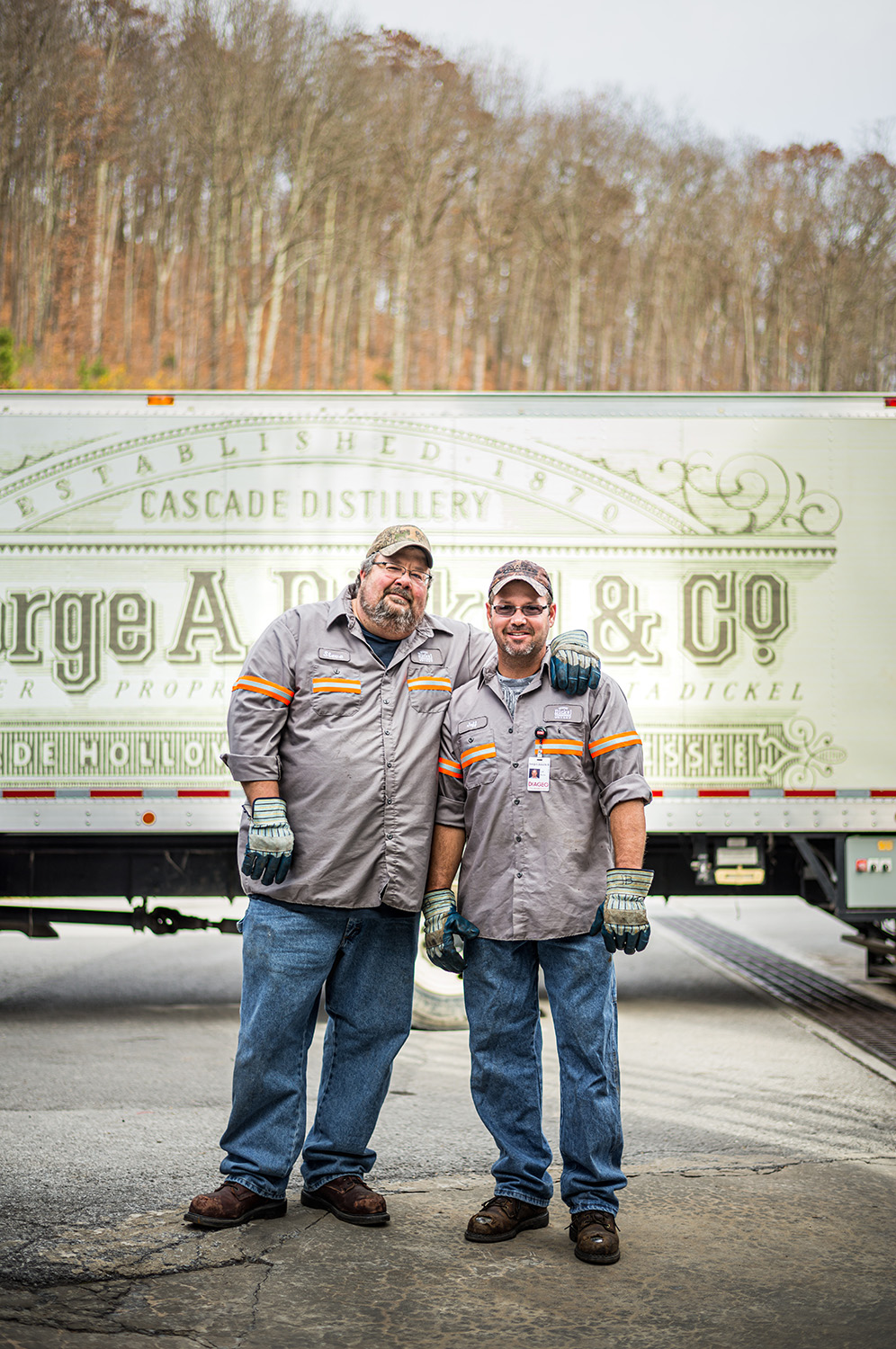 Portrait of two men wearing work safety uniforms and standing in front of a truck at George Dickel Whisky Distillery in Tennessee | Nashville, reportage, industrial, product, and brand story by Nashville editorial photographer Kristina Krug.