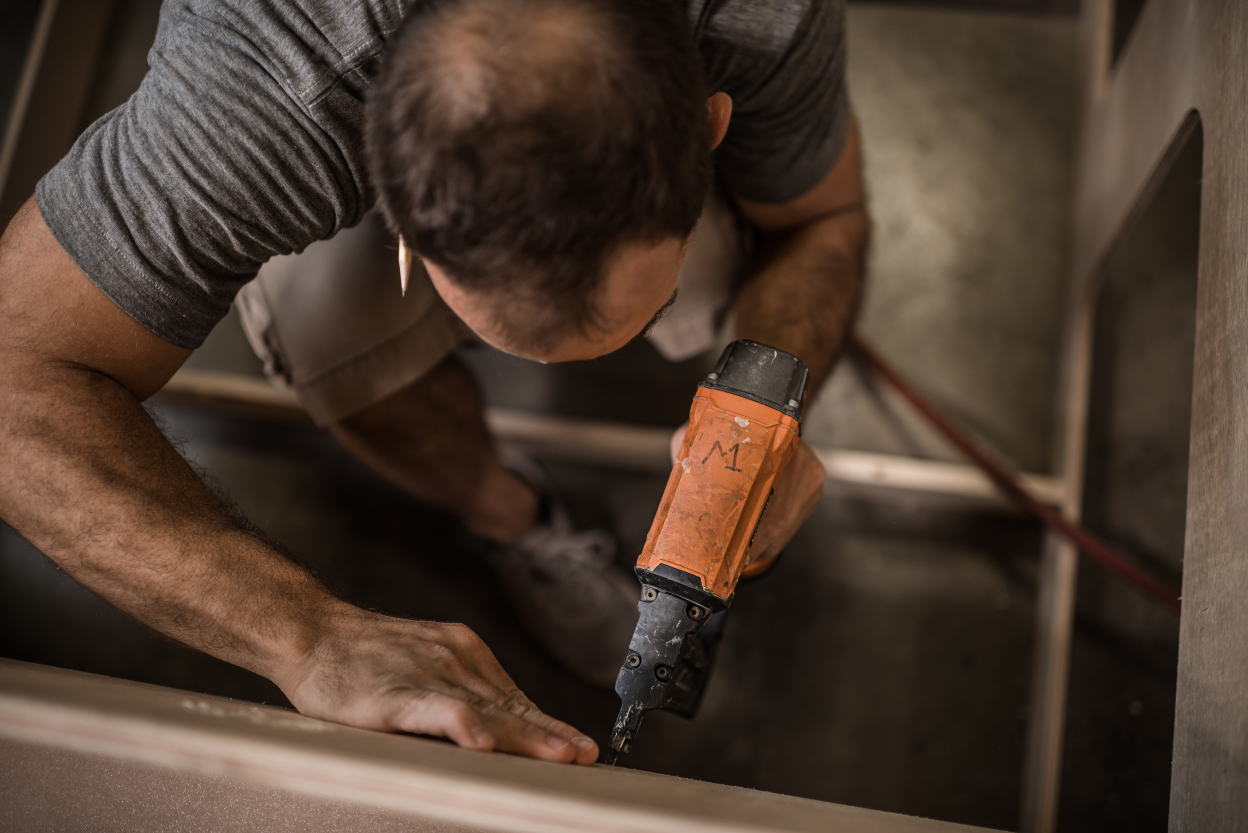 Man at work with staple gun tool at the Nashville industrial construction custom builder MadeFIrst, by commercial photographer Kristina Krug