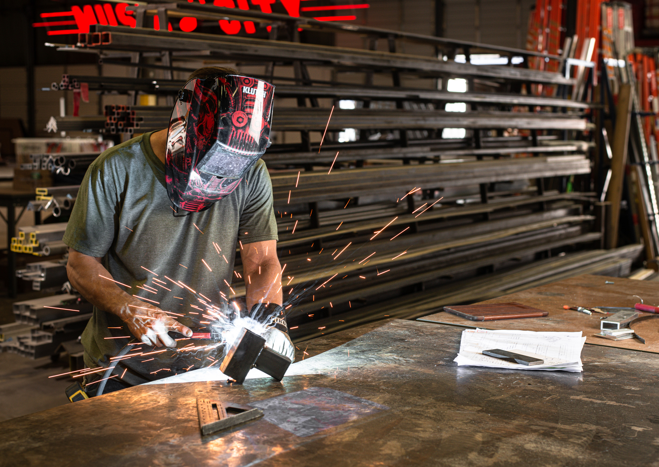 Man at work using a welding torch with sparks, in a metal tool shop by Seattle, Portland, and Nashville, industrial and commercial photographer, Kristina Krug