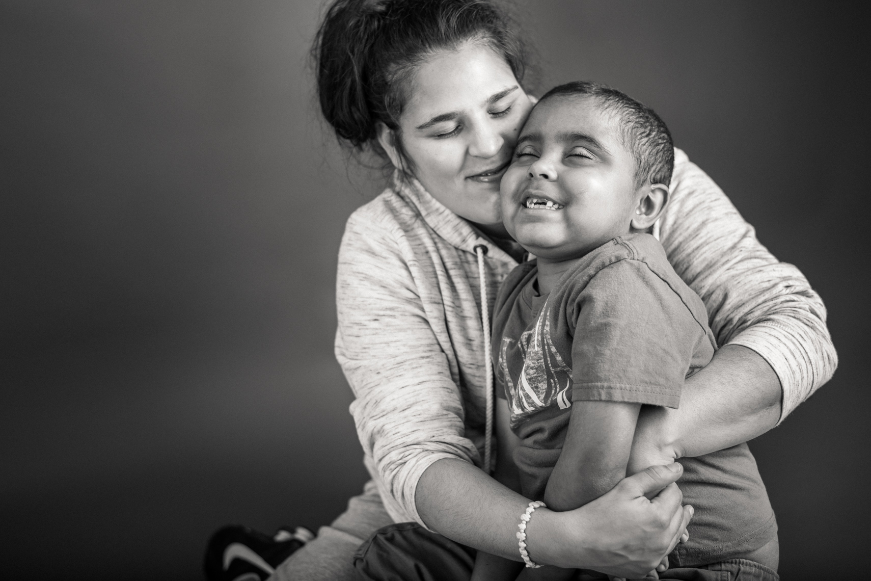 Flashes of Hope, portrait of a young boy batting cancer, being hugged by his mother. Family support, hug, loving, warm, together, resilience, authentic, love, Nashville, portrait, editorial, reportage, news, photographer, portraiture